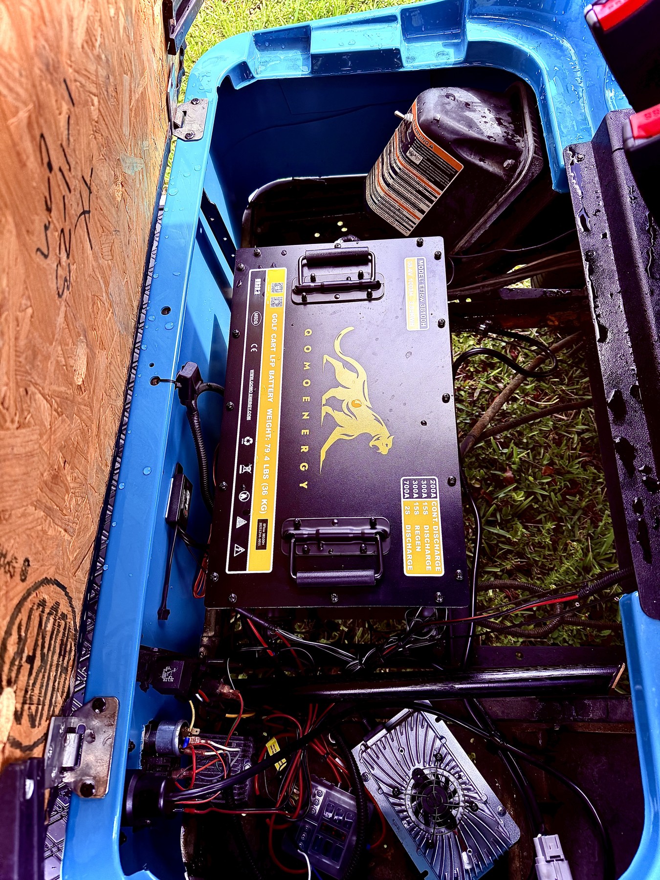 High-capacity black lithium battery installed inside a blue golf cart battery bay