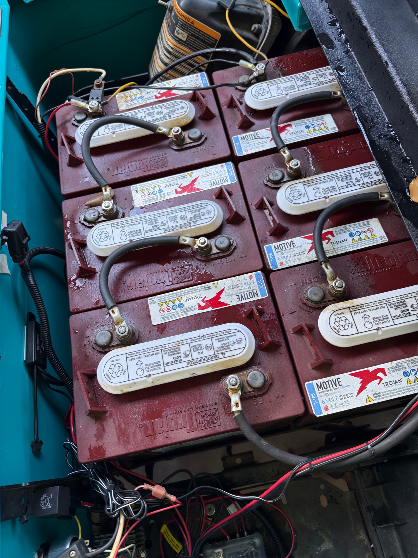 Six Trojan 6-volt lead-acid batteries installed in a golf cart battery bay